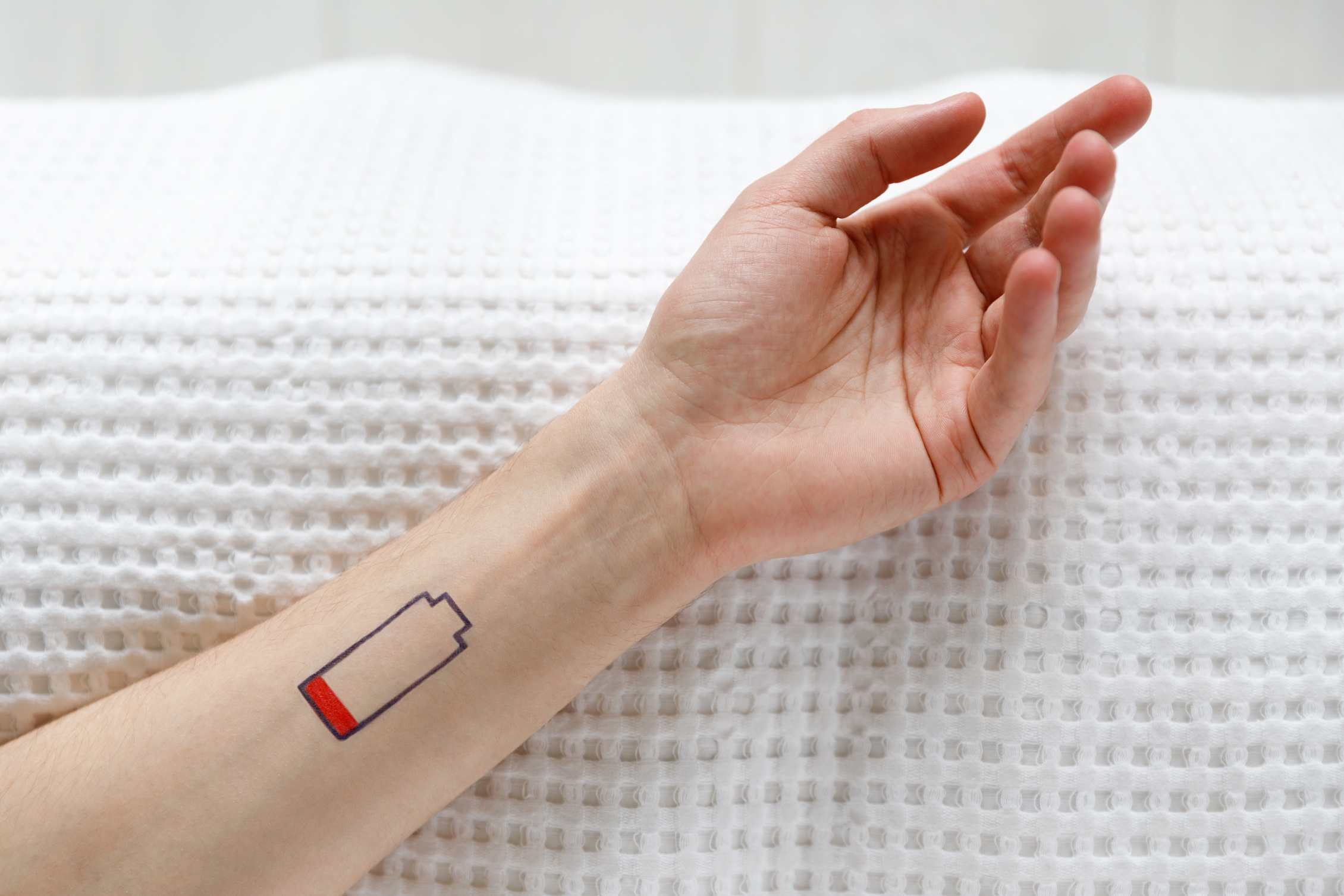 Low battery symbol drawn on human hand, chronic fatigue