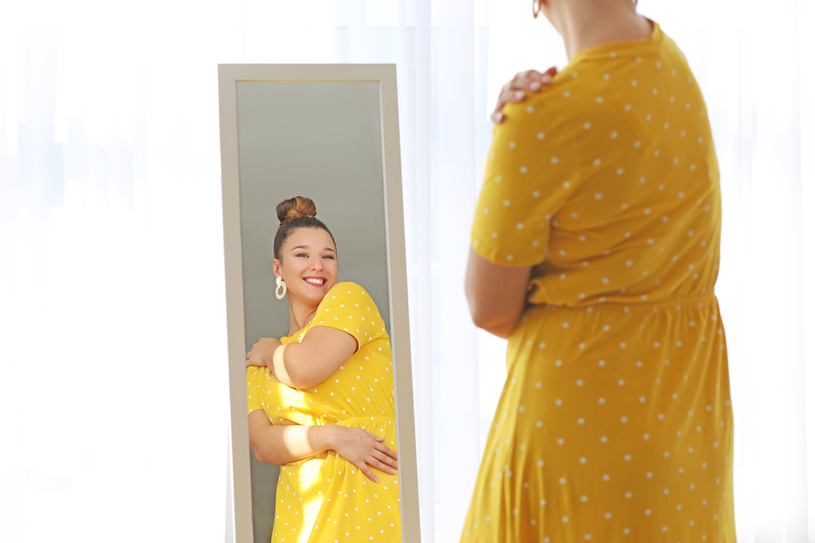 Happy Curvy Woman Looking in Mirror at Home